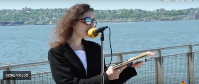 Lady recites poetry in celebration of Walt Whitman's 200th Birthday alongside New York Harbor.